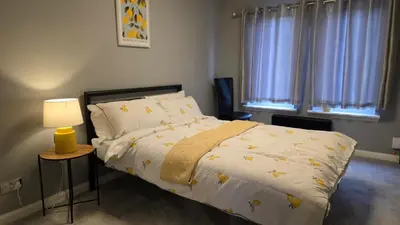 a bedroom with a bed and a lamp and windows at The Ansi8 in Livingston