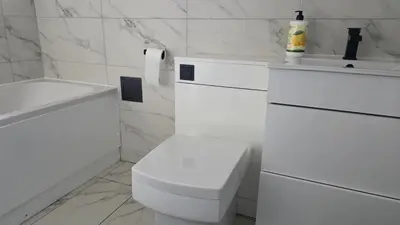 a white bathroom with a toilet and a sink at The Ansi8 in Livingston