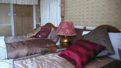 a bedroom with a bed and a lamp on a table at Sandilands House in Edinburgh