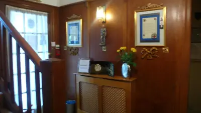 a hallway with a staircase with a vase of flowers at Sandilands House in Edinburgh