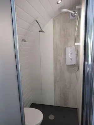a bathroom with a shower and a toilet at Squirrels Wood Lodge, nr Glencoe, dog friendly in Acharra
