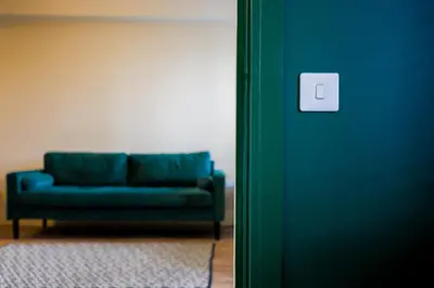 a blue couch in a living room next to a door at Netherbrae Apartment in Oban
