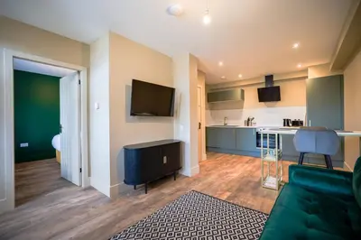 a living room with a couch and a kitchen at Netherbrae Apartment in Oban
