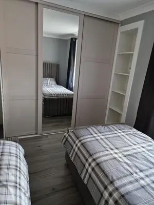 a bedroom with a bed and a mirror in a room at The Cottage in Kirk of Shotts