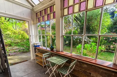 a room with windows and a table and chairs at Victorian Charm - Lush Garden, Shops and Parking in Edinburgh