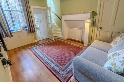 a living room with a couch and a rug at Victorian Charm - Lush Garden, Shops and Parking in Edinburgh