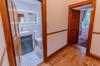 a bathroom with a toilet and a sink and a mirror at Victorian Charm - Lush Garden, Shops and Parking in Edinburgh