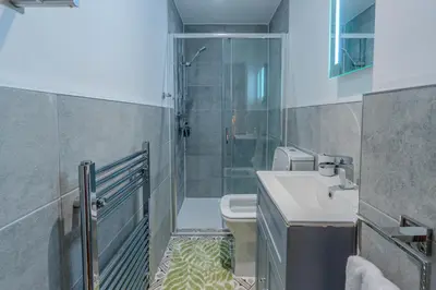a bathroom with a shower and a sink and a toilet at Victorian Charm - Lush Garden, Shops and Parking in Edinburgh