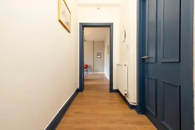 a hallway with two blue doors and a wooden floor at Stylish 1-Bedroom Edinburgh Apartment in Edinburgh