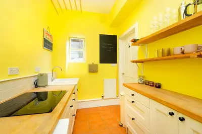 a kitchen with a sink and a yellow wall at Stylish 1-Bedroom Edinburgh Apartment in Edinburgh
