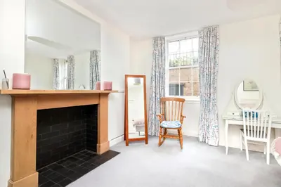 a living room with a fireplace and a mirror at Charming Edinburgh Apartment with 2-Bathroom and Private Entrance in Edinburgh