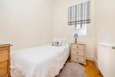 a bedroom with a bed and a dresser and a window at Charming Edinburgh Apartment with 2-Bathroom and Private Entrance in Edinburgh