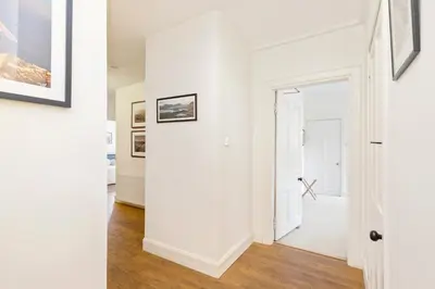 an open hallway with white walls and wood floors at Charming Edinburgh Apartment with 2-Bathroom and Private Entrance in Edinburgh