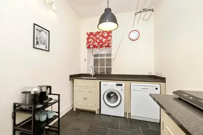 a laundry room with a washer and dryer at Charming Edinburgh Apartment with 2-Bathroom and Private Entrance in Edinburgh