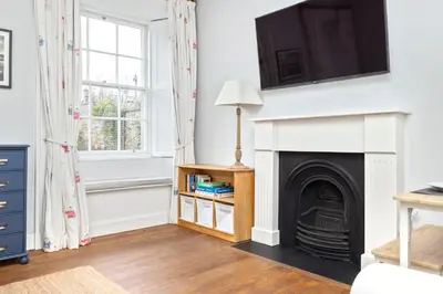 a living room with a fireplace and a tv at Charming Edinburgh Apartment with 2-Bathroom and Private Entrance in Edinburgh
