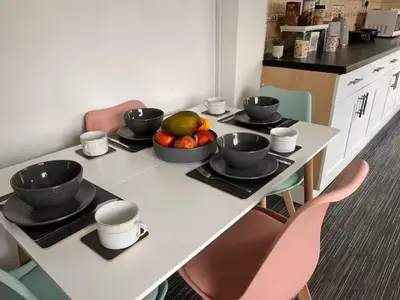 a table with bowls of fruit on top of it at 5BR House w Garden Near Stadium in Moffat