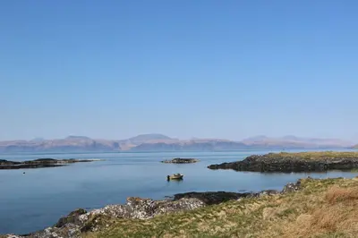 a small boat in a large body of water at Fladda in Oban