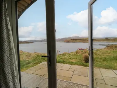 an open door with a view of a body of water at Creags in Oban