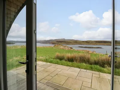 an open door to a view of a body of water at Erraid in Oban