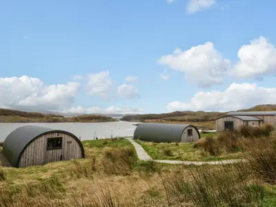 a group of domes in a field next to a body of water at Erraid in Oban