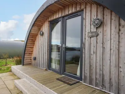 a wooden cabin with a large glass door at Erraid in Oban