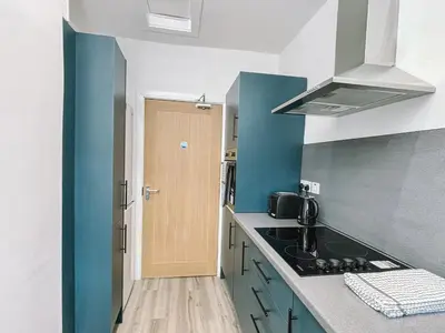 a kitchen with blue and white walls and a counter top at Itohan 3-bed Cottage Flat in Glasgow