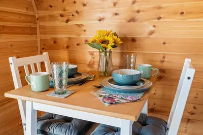 a wooden table with a vase of flowers on it at The Pods at 7 Black Crofts in Oban
