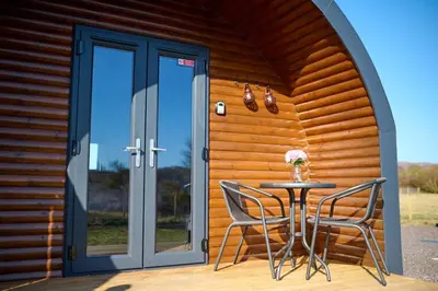 a table and chairs in front of a wooden house at The Pods at 7 Black Crofts in Oban