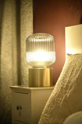 a lamp on a night stand next to a bed at KKLM Holidays in Largs