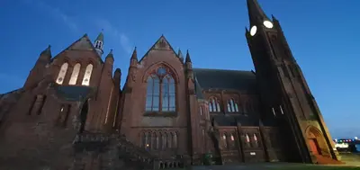 an old church with a clock tower at night at KKLM Holidays in Largs