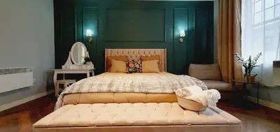 a bedroom with a large bed with a green wall at KKLM Holidays in Largs