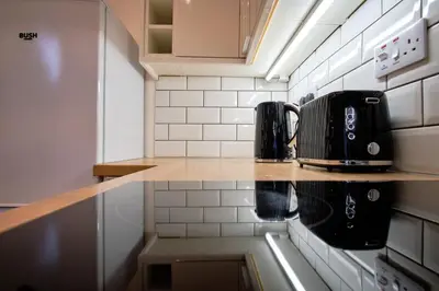 a kitchen counter with affeepot on top of it at 2 bedroom, newly-renovated, comfortable town centre apartment! in Oban