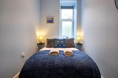 a bedroom with a bed with two towels on it at 2 bedroom, newly-renovated, comfortable town centre apartment! in Oban
