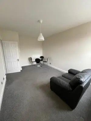 a living room with a black leather couch and chairs at London Holiday Home - 8mins walk from Station Zone 2 in Moffat