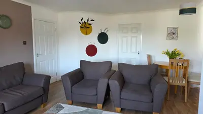 a living room with two chairs and a table at The Ansi9 in Livingston