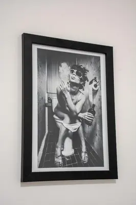 a black and white photo of a woman sitting on a toilet at Bartonshill House in Glasgow