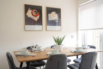 a dining room with a wooden table and chairs at Bartonshill House in Glasgow