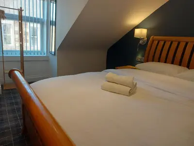 a large white bed with two towels on it at Hotel Room in Maybole for Work Travel & Leisure in Maybole