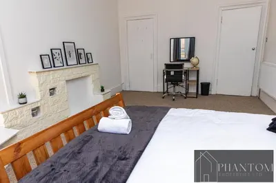 a bedroom with a bed and a fireplace at Complexx Suite in Glasgow