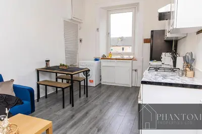 a kitchen with a table and a counter top at Complexx Suite in Glasgow