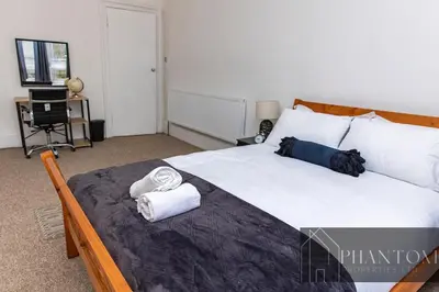 a bedroom with a large bed with towels on it at Complexx Suite in Glasgow