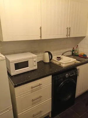 a kitchen with a microwave and a stove top oven at Kaffuhsmartt in Drumchapel