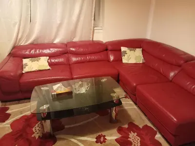 a living room with a red couch and a glass table at Kaffuhsmartt in Drumchapel