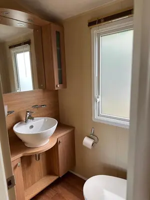 a bathroom with a sink and a toilet and a window at The Grosvner 61 in Dunoon