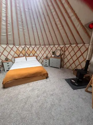 a bedroom with a bed in a yurt at Bracken Barns Glamping & Massage in Minishant