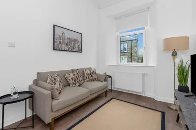 a living room with a couch and a window at Appin House -Cosy 2 bed house in Dunfermline in Dunfermline