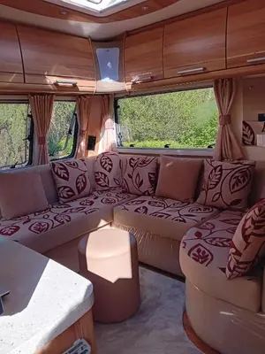 a living room in an rv with a couch and chairs at Railway cottage caravan in Oban