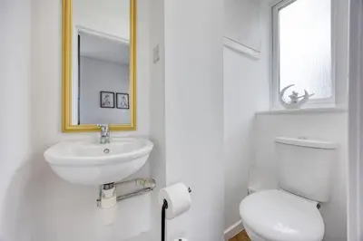 a white bathroom with a sink and a toilet at 2 Bedroom in the Heart of Loch Lomond in Balloch