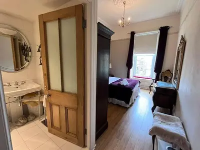 a bathroom with a bedroom with a bed and a sink at Wonderful 3 Bed West End Flat in Glasgow