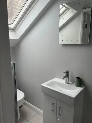 a bathroom with a sink and a mirror and a toilet at Lovely spacious home near station in Moffat